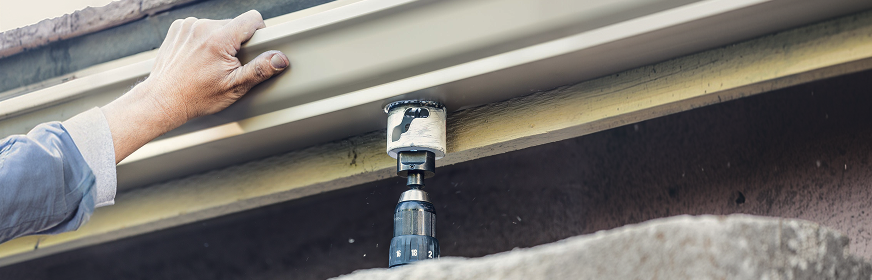 installing gutter guard system on residential roof edge